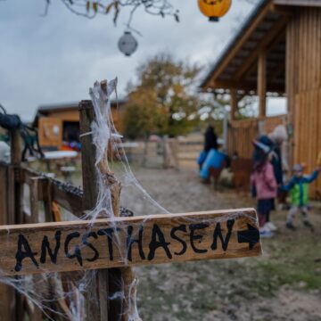 Halloween-dekorierter Eingang mit Wegweiser „Angsthasen" auf dem Sonnenland Alpakas Hof Halloween-dekorierter Eingang mit Wegweiser „Angsthasen" auf dem Sonnenland Alpakas Hof